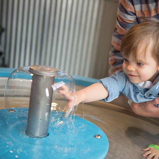 boy playing with a water bell